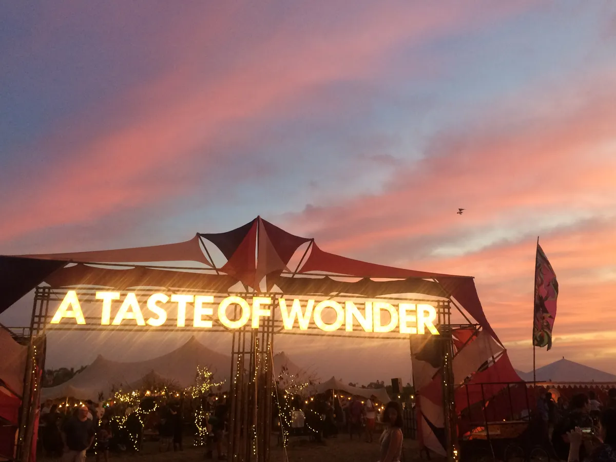 A gate reading A Taste of Wonder at sunset at the 2015 Wonderfruit festival
