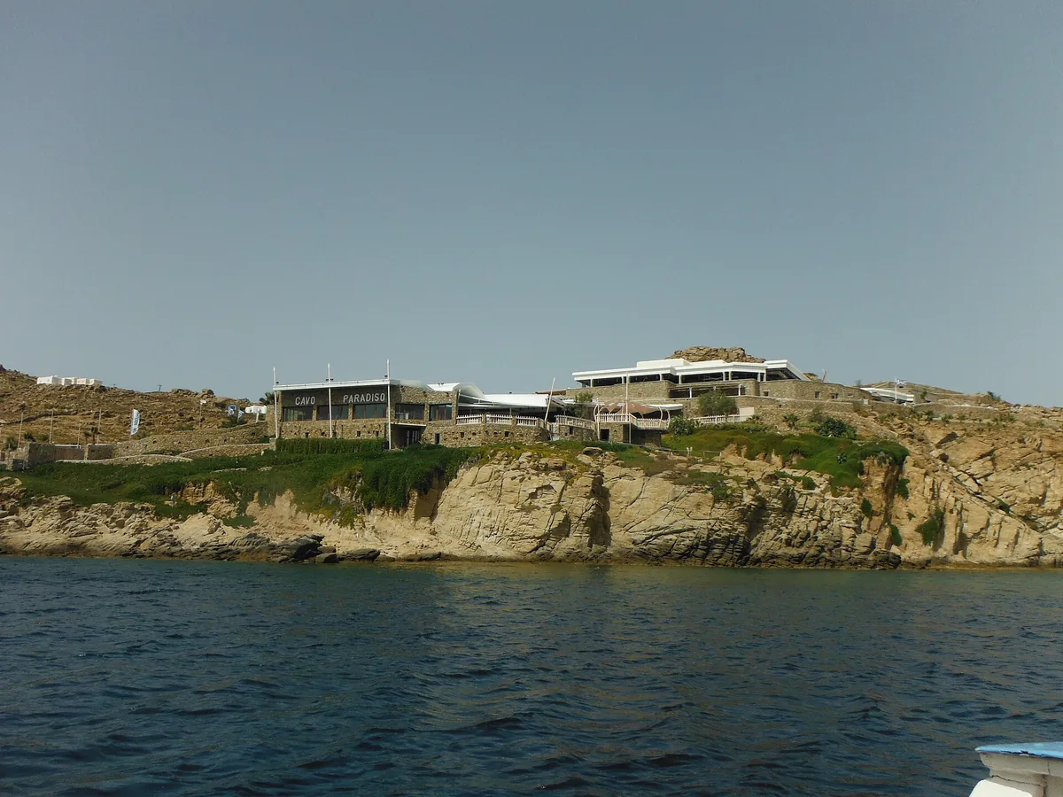 Cavo Paradiso on its cliff above the sea in Mykonos, seen from the water