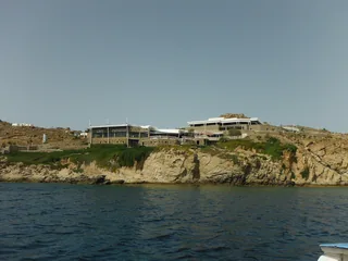 Cavo Paradiso on its cliff above the sea in Mykonos, seen from the water