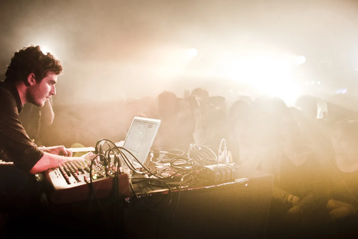 Nicolas Jaar playing live at Rex Club in Paris in a haze of smoke and stage light