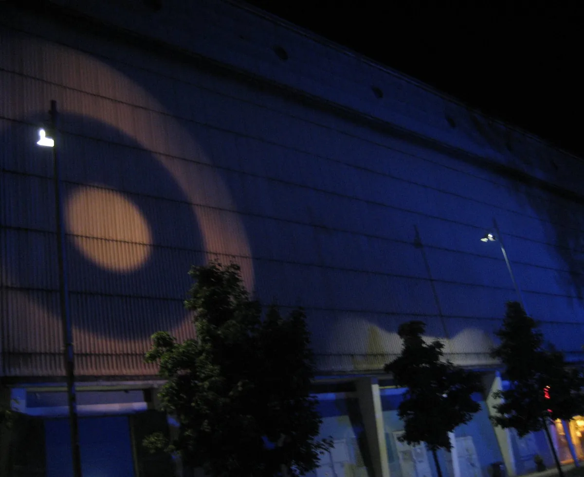 The lit blue exterior wall at night of the former power station building in Berlin that houses the Tresor club