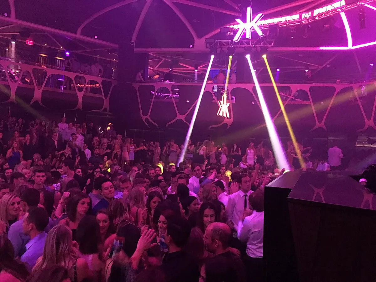 Hakkasan in Las Vegas, a packed dance floor under pink lights with the DJ booth at right