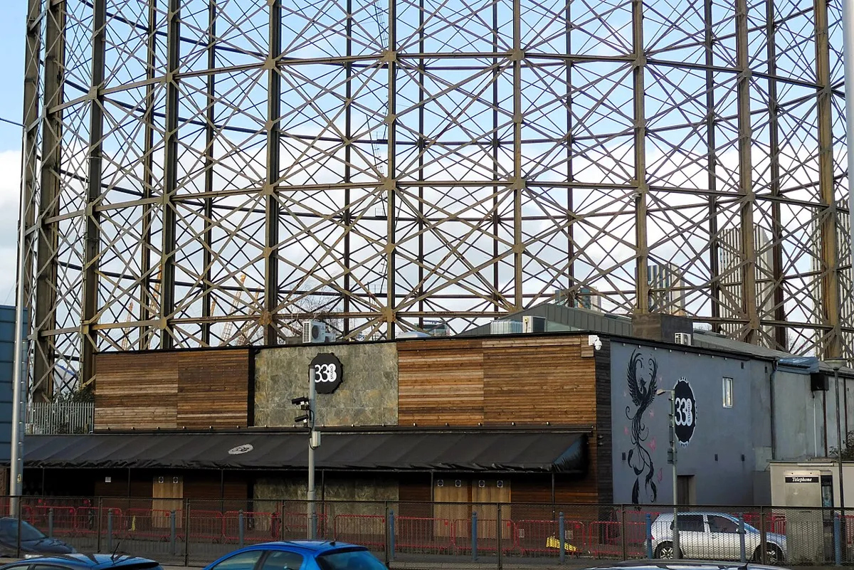 The Studio 338 building on the Greenwich Peninsula with a gasholder frame rising behind it
