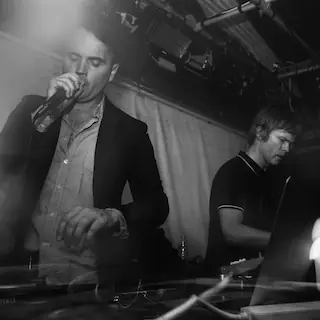 British electronic music artists performing in a dark club