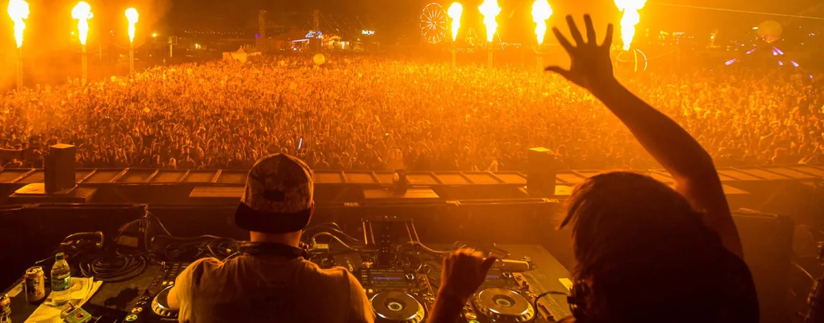 Camo & Krooked seen from behind the decks at EDC Las Vegas in 2014, flame cannons over a large crowd