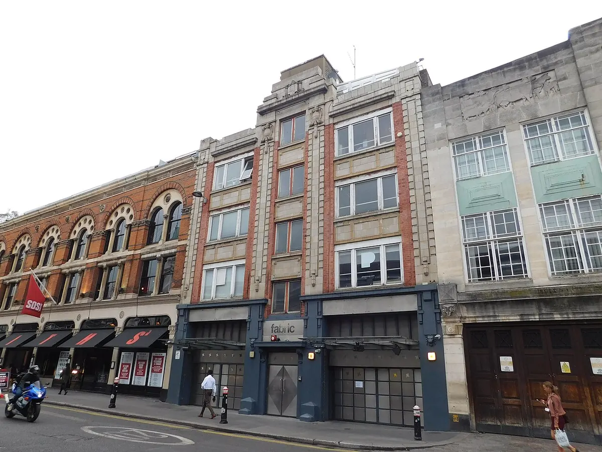 The front of fabric on Charterhouse Street in London, a narrow stone and brick building between two larger ones, with its name above the doors
