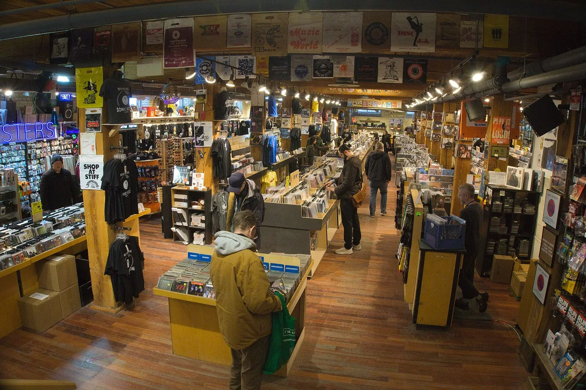 The interior of a second-hand record shop, racks of vinyl along both walls