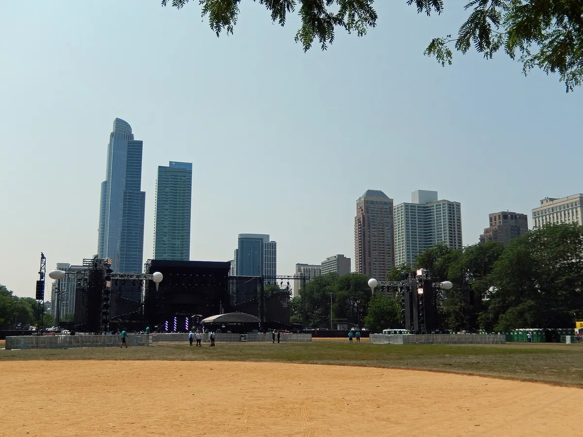 An empty main stage in Grant Park on the morning of Lollapalooza 2014, dirt ground in front and lakefront towers behind