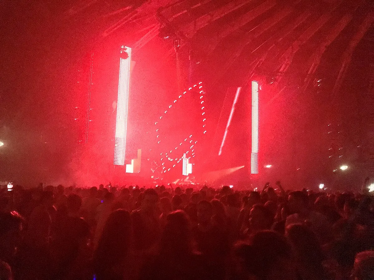 Red light beams and a lit rig over the crowd inside the Gashouder at Awakenings in Amsterdam