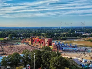 The Parookaville Mainstage from the air in 2022, with the crowd in front of it and wind turbines on the horizon