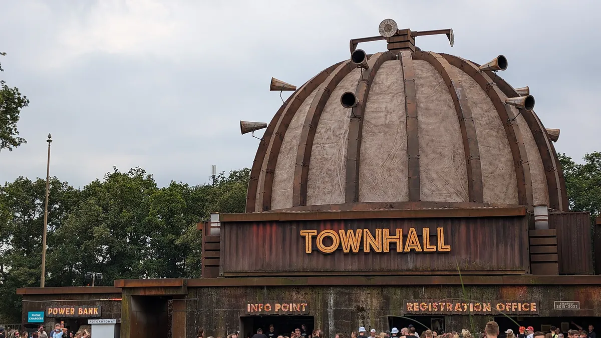 The Parookaville town hall, a domed building with horns on its roof and TOWNHALL in lit letters above an info point and a registration office