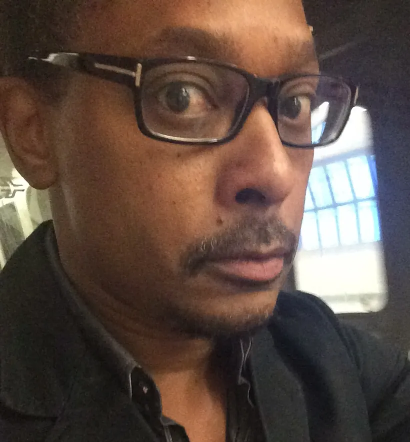 Close portrait of Derrick May in glasses and a dark jacket