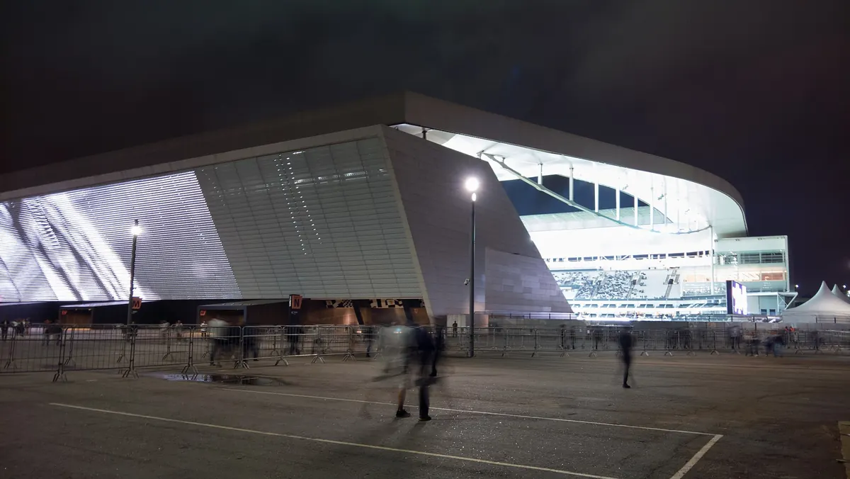 The Neo Química Arena stadium in São Paulo at night, with a giant screen on its outer wall