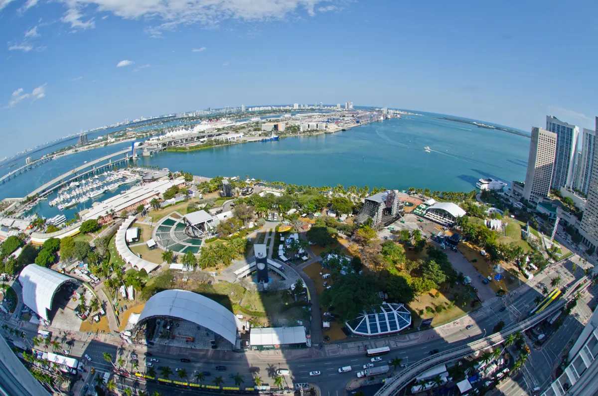 A fisheye panorama of Bayfront Park set up for Ultra in 2013, with stage structures and tents between the Miami skyline and the bay