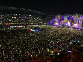 A packed crowd with phone lights in front of the Untold main stage at night in 2019